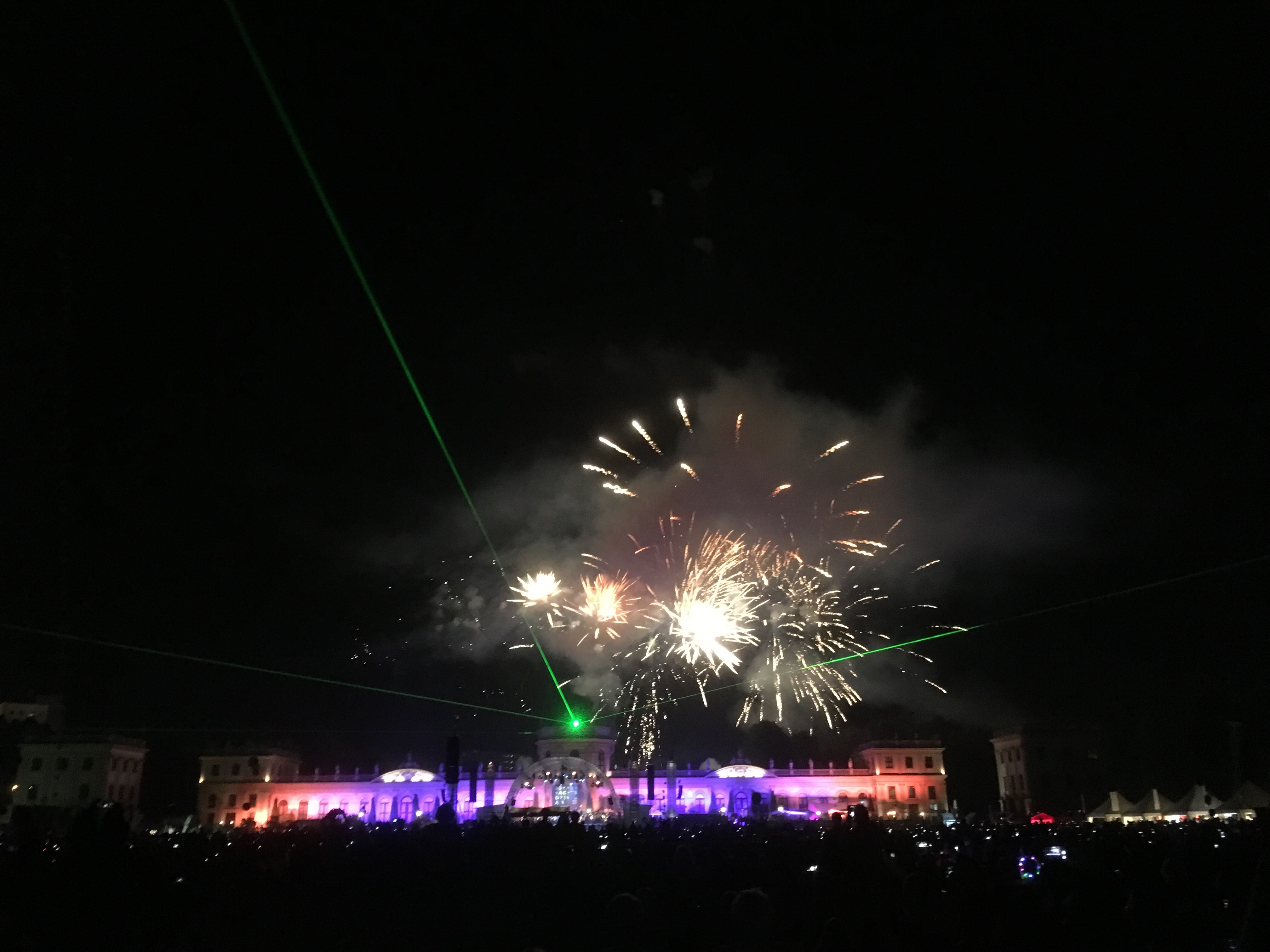 Feuerwerk hinter der lila-orange beleuchteten Orangerie